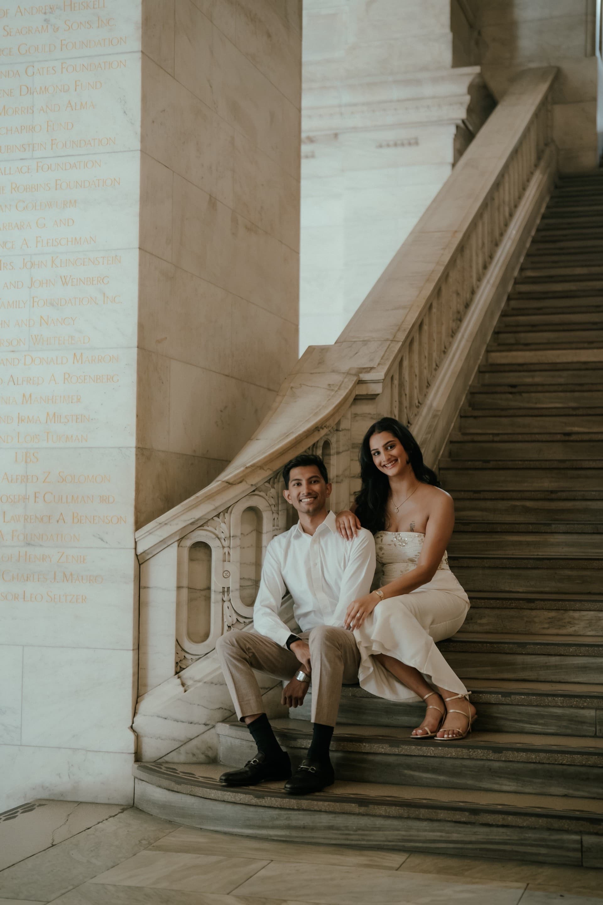 Ananya and Varun seated together on a marble staircase